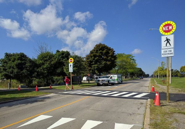 A rendering of a pedestrian crosswalk across Highway 2 with signage to indicate the need to stop.